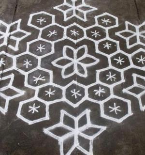a rangoli design on a concrete floor