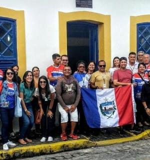 a group of people standing in front of a building with a flag