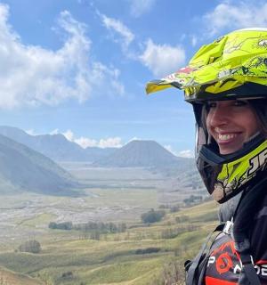 žena s helmou na vrcholu hory