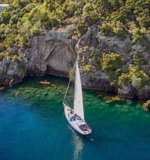 山边水中的一艘扬帆的船