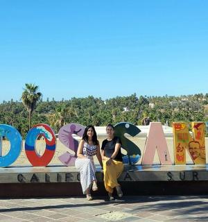 两名女子坐在西奥多标志前