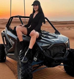 a woman sitting on a atv in the desert