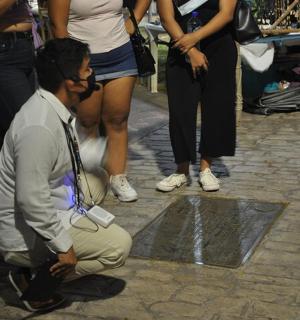 a man squatting on the ground in a crowd of people