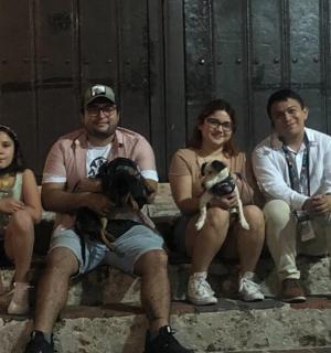 a group of people sitting on steps with their dogs