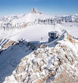 a snow covered mountain with a building on top of it