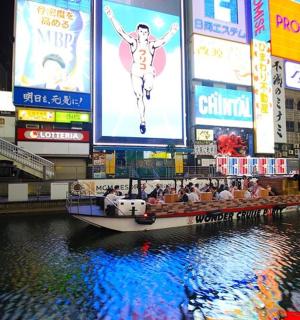 一座城市河流中的一艘船，上面有广告牌