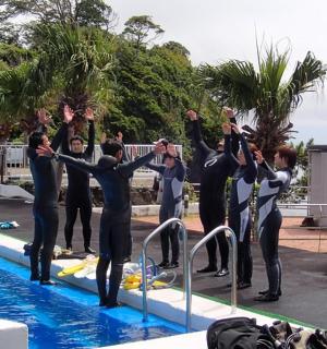 一群穿着潜水服的人站在泳池边