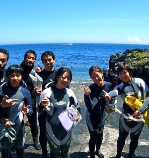 一群穿着潜水服的人站在海边