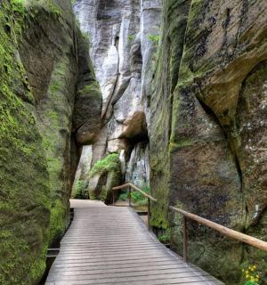 a wooden path through a mountain cliff with a bridge