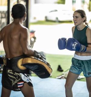 a boy and a girl with boxing gloves in a gym