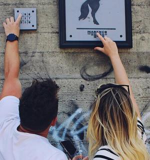 a man and a woman reaching for a sign on a wall