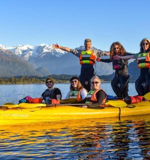 a group of people in a yellow kayak on a lake