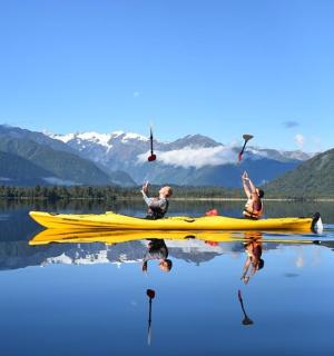 two people on a yellow kayak on a lake