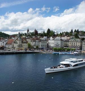 loď na řece s městem v pozadí