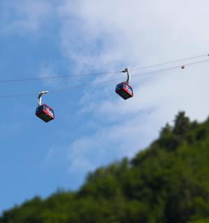 dva lyžařské vleky na laně se stromy v pozadí