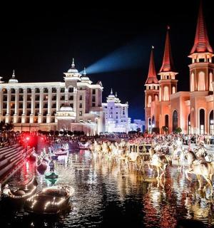 a group of animals in the water in a city at night