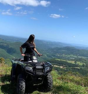 一名女子站在山顶上的一辆全地形车上