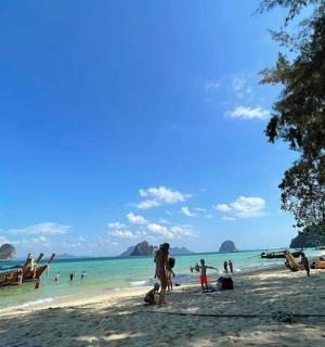 一群人在海滩上，水里有船