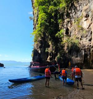 一群人站在海滩上，旁边是一艘船