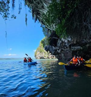 一群人在洞穴附近的水中划皮划艇