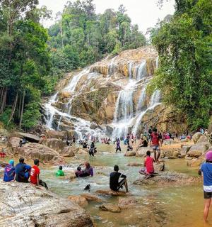 一群人在有瀑布的河流中