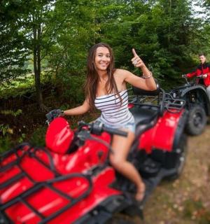 一名女子坐在一辆四轮摩托车上