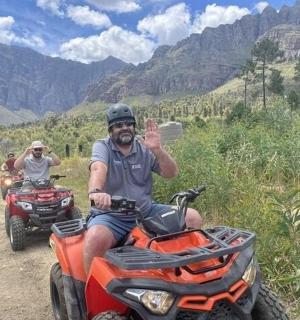 两个人骑着四轮摩托车在土路上行驶