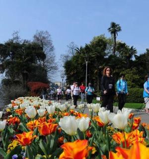 skupina lidí stojící vedle květinového pole