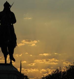a statue of a man on a horse at sunset