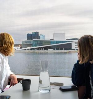 两个女人坐在桌边看着水