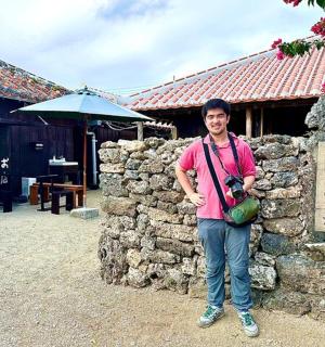 a man standing in front of a stone wall
