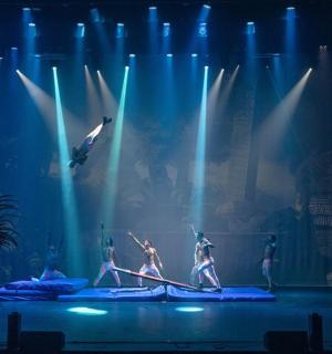 a group of performers on a stage with blue lights