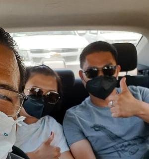 三个戴着口罩的人坐在车里