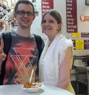 a man and a woman standing at a table with a bowl of food