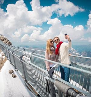 en mand og kvinde tager et billede på toppen af et bjerg
