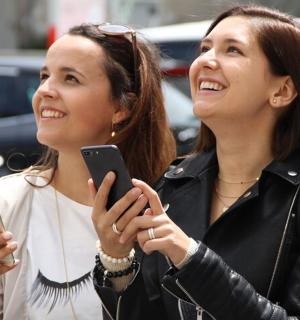 两个女人一边看着手机一边笑