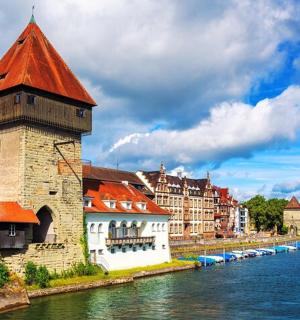 a building with a red roof next to a river