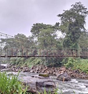 en person, der krydser en hængebro over en flod