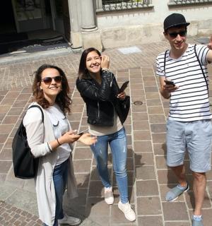 two women and a man posing for a picture with their cell phones
