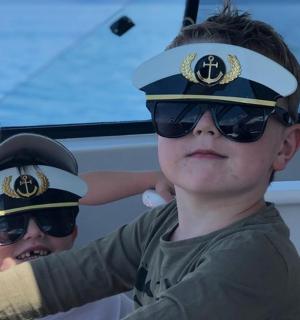 两个戴着墨镜和船长帽的小男孩