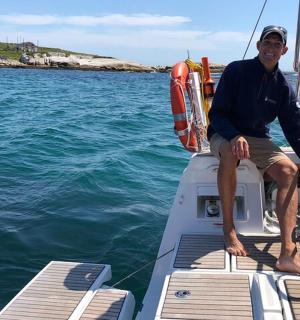 a man sitting on the front of a boat in the water