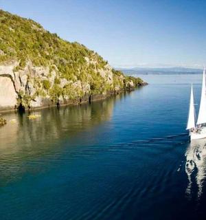 小岛旁边水中的一艘船