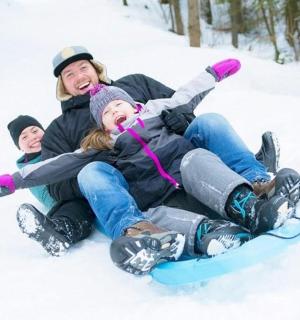muž a dvě děti na snowboardu ve sněhu