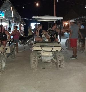 a group of people standing around atvs in the dirt