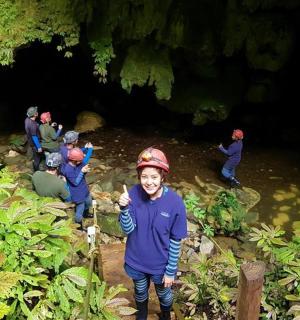 muž stojí před jeskyní