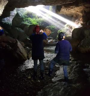 skupina lidí fotících v jeskyni