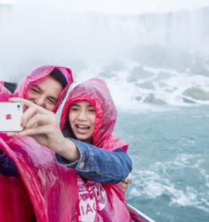 一名男子和一名女孩用手机拍照