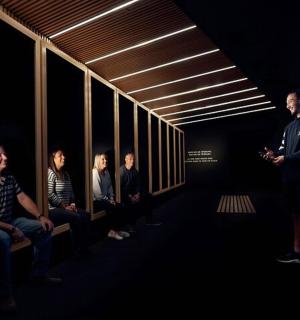 一名男子和一群人站在黑暗的房间里