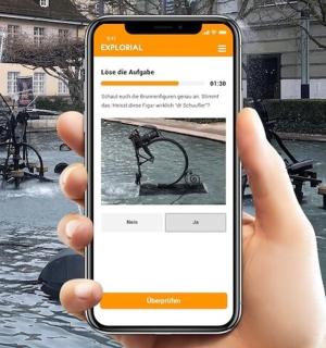 喷泉前拿着手机的手