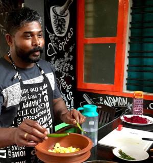 muž stojící v kuchyni a připravující jídlo